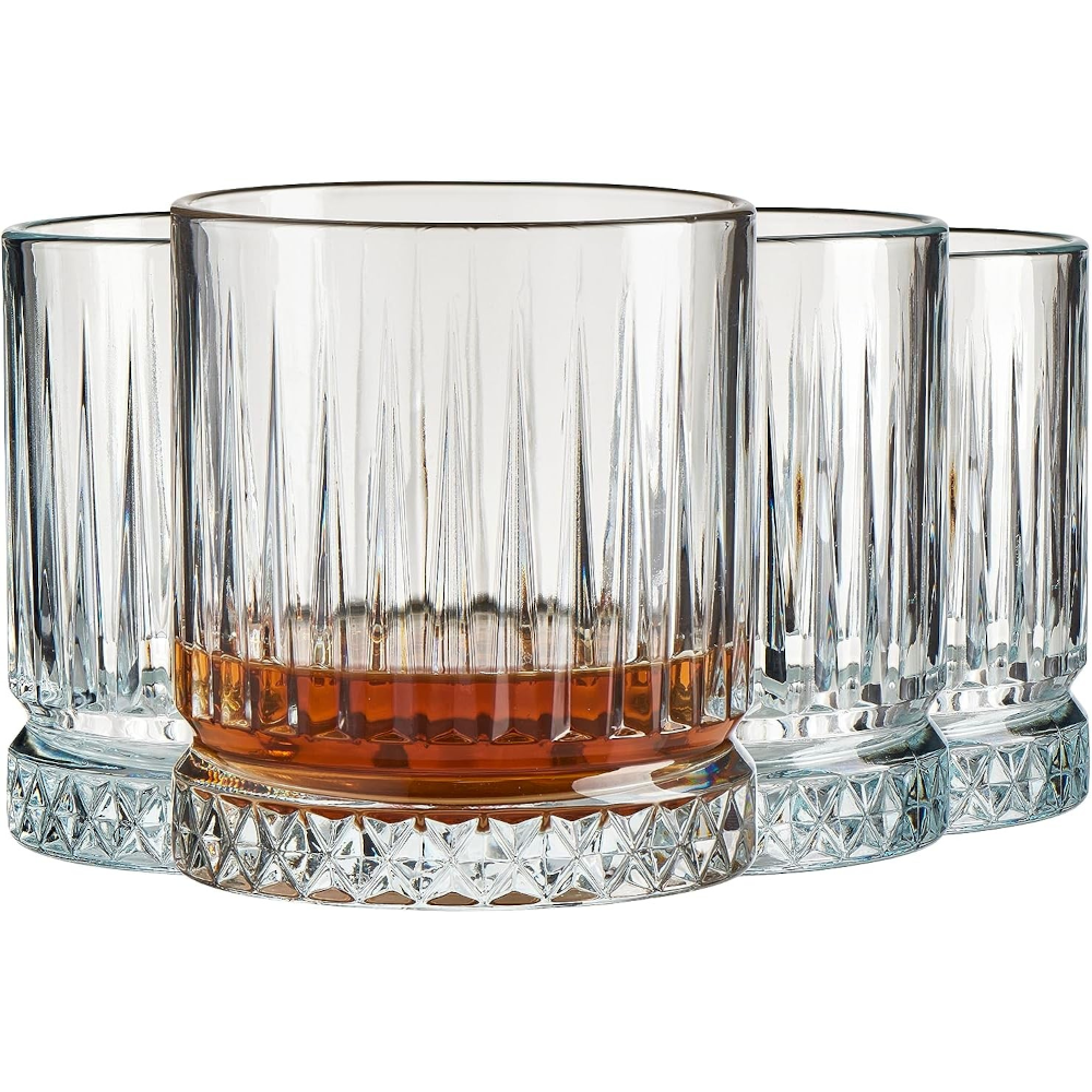 Trei pahare tip tumbler cu dungi verticale pline cu cocktail de culoarea chihlimbarului si gheata, asezate pe un fundal intunecat si estetic de bar.