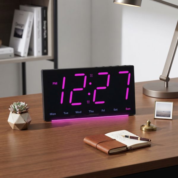 Ceas digital LED de birou cu carcasa neagra si afisaj violet cu lumina ambiental la baza.